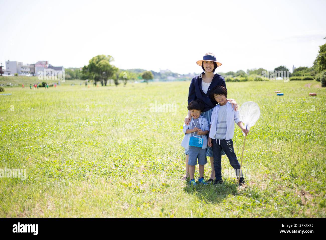 Geschwister und Mutter mit Insektennetzen auf der Wiese Stockfoto