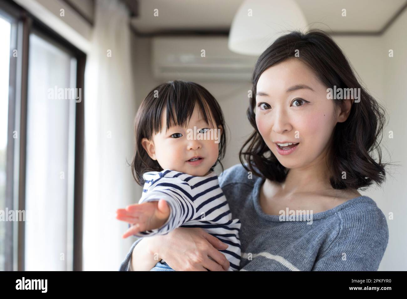 Das Kind wird von der Mutter getragen Stockfoto