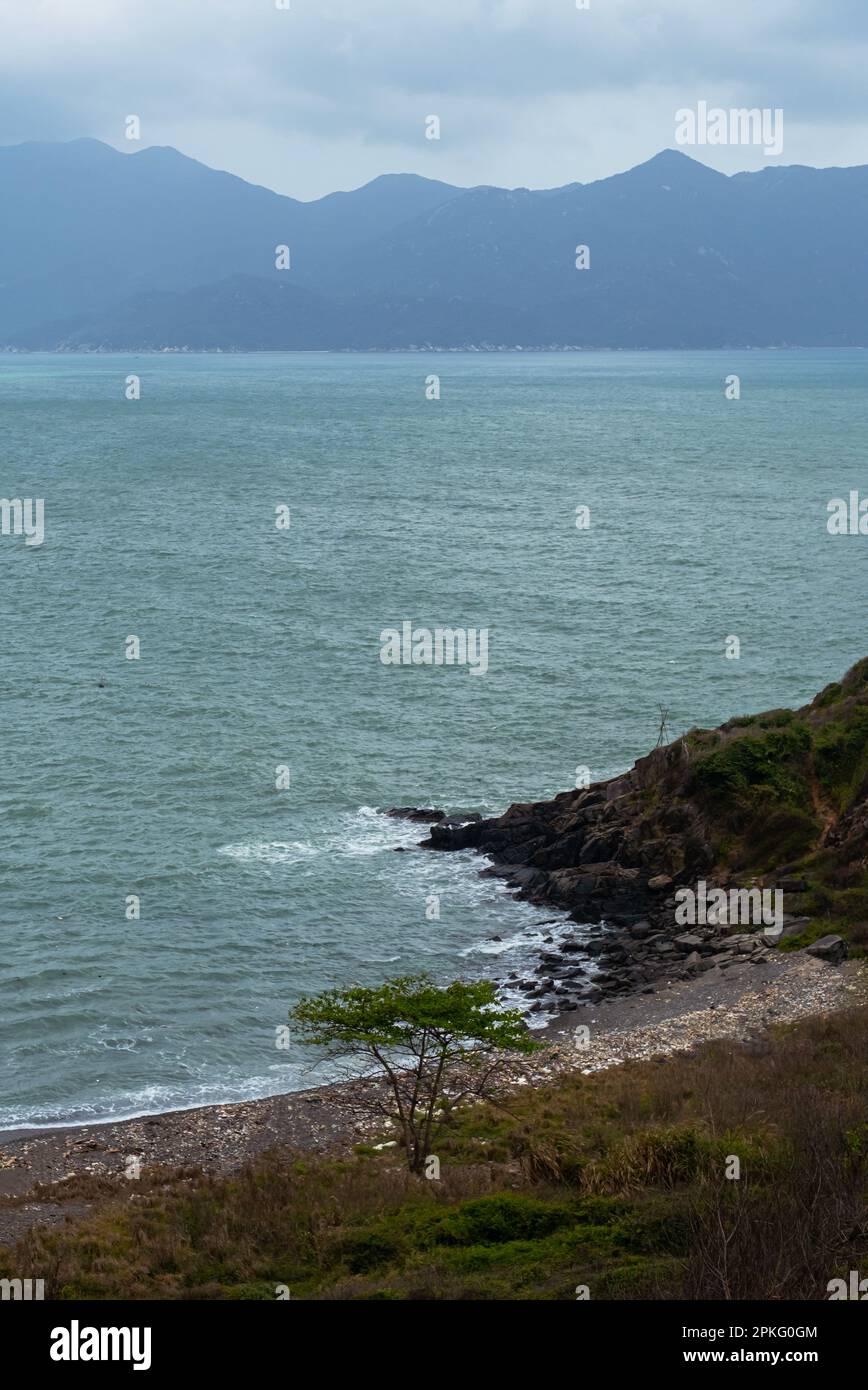 Wunderschöne Meereslandschaft. Ruhiger Ozean vor nebligen Bergen. Stockfoto