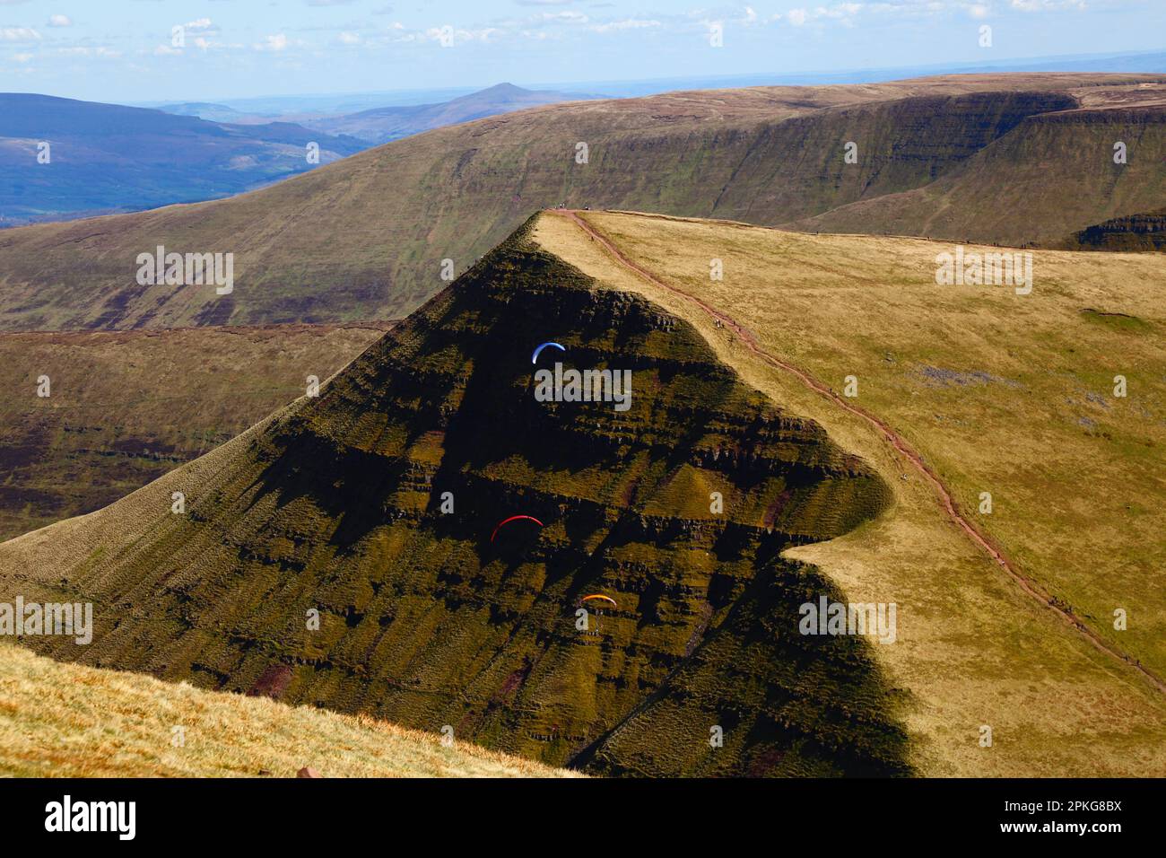 UK Weather: Karfreitag-Feiertag, 7. April 2023. Brecon Beacons National Park, Südwales. Gleitschirmfliegen vor der Nordseite des Cribyn Peak, einem der Gipfel des Hauptkamms der Brecon Beacons Range im Brecon Beacons National Park. Das schöne, sonnige Wetter bedeutete, dass viele Leute die Reise in den Park für den heutigen Feiertag machten. Stockfoto