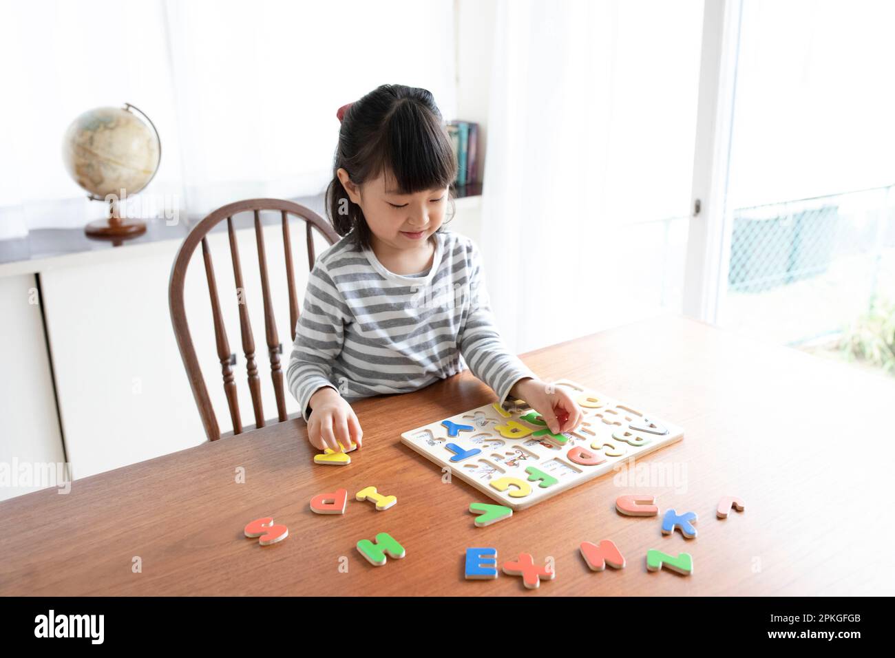 Ein Mädchen, das ein Alphabet-Puzzle macht Stockfoto