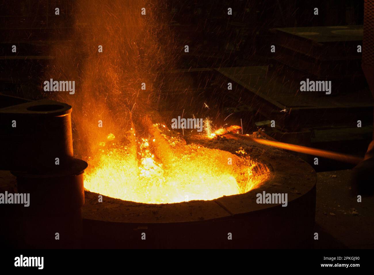 Eisen-Stahl ist in einem Hochtemperaturofen geschmolzen. Der Prozess, der unter sehr schwierigen Bedingungen durchgeführt wird, ist auch Schauplatz visueller Feinheiten Stockfoto