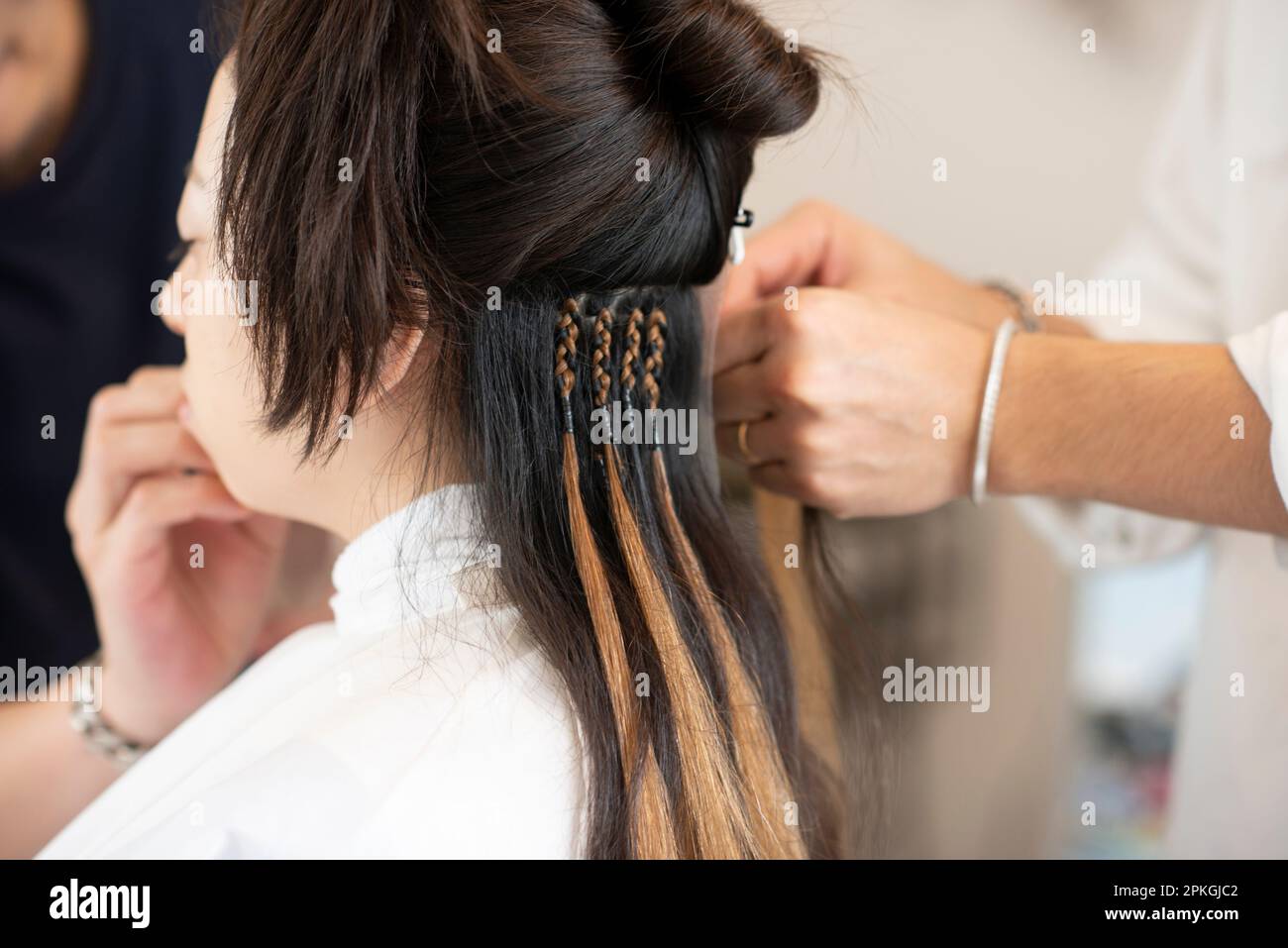 Friseurhand mit Haarverlängerungen Stockfoto