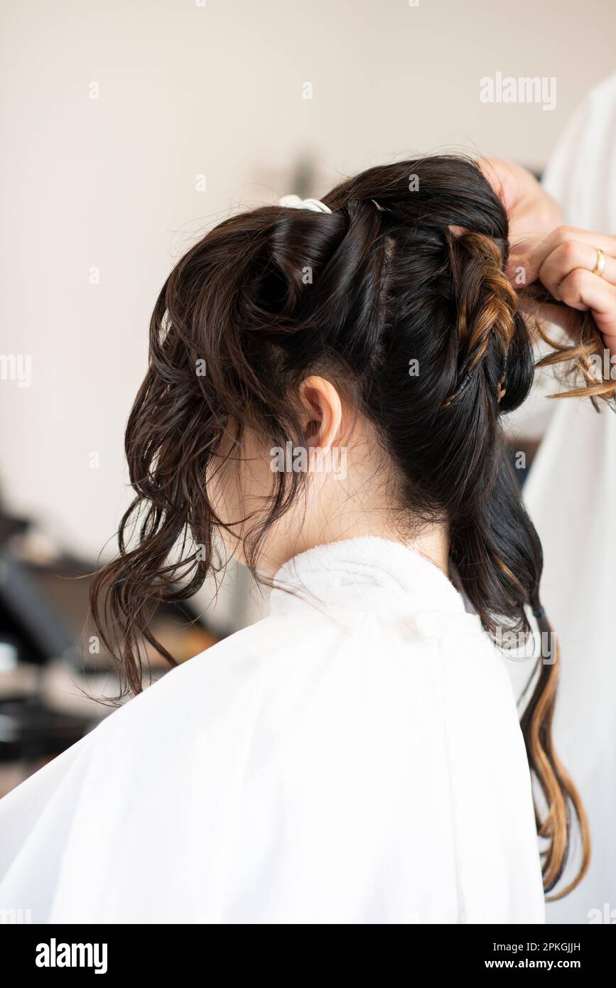 Eine Frau, die ihre Haare von einer Kosmetikerin frisiert Stockfoto