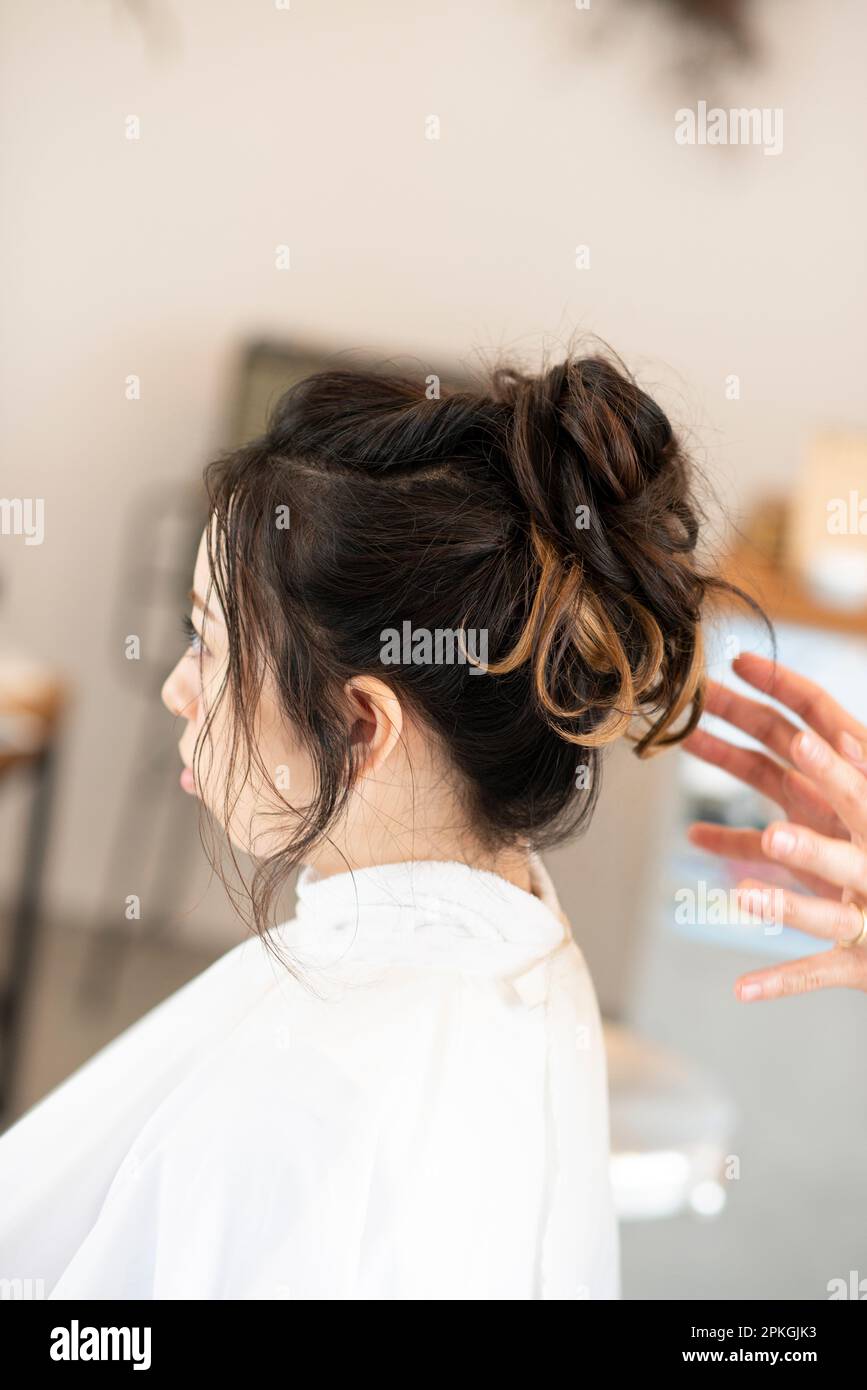 Eine Frau, die ihre Haare von einer Kosmetikerin frisiert Stockfoto