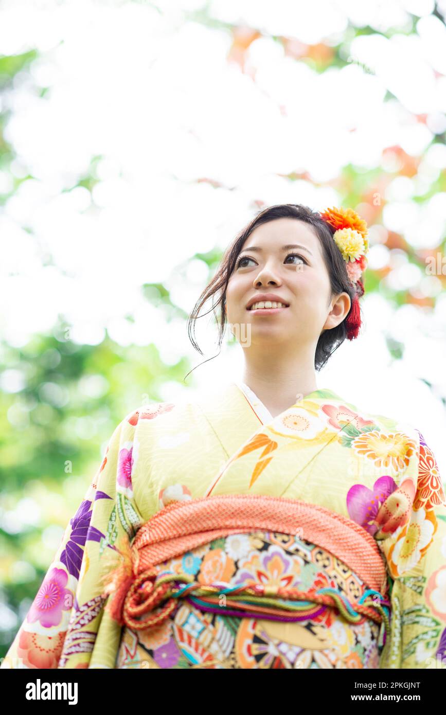Eine Frau in Kimono, die im Wald lächelt Stockfoto