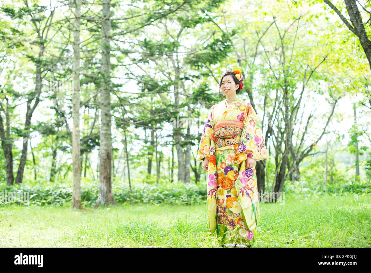 Eine Frau in Kimono, die im Wald steht Stockfoto