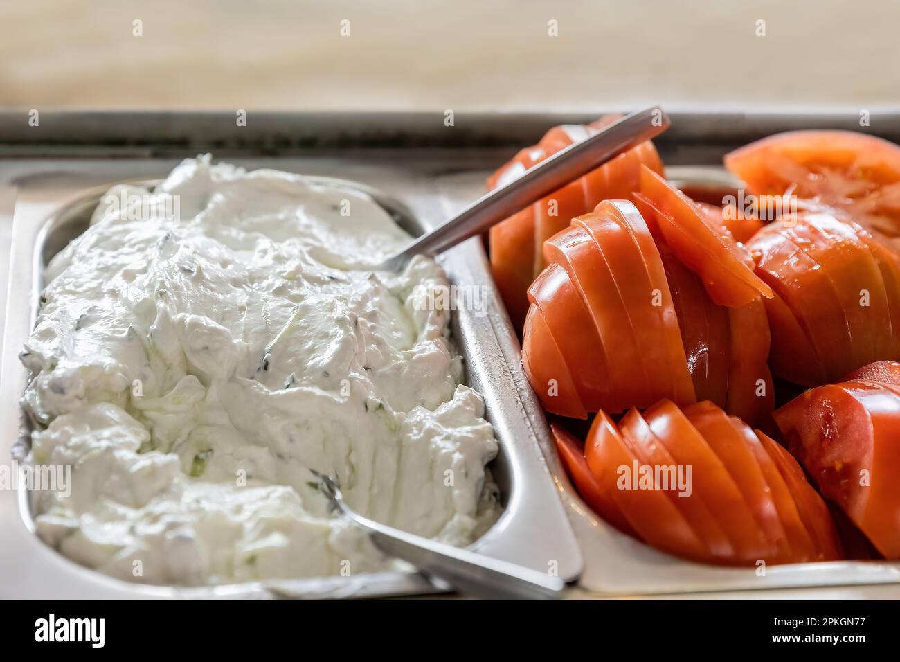 Tzatziki-Salat und Tomatenscheiben, fertig für Pita Gyros, griechisches traditionelles Wrap-Sandwich Stockfoto