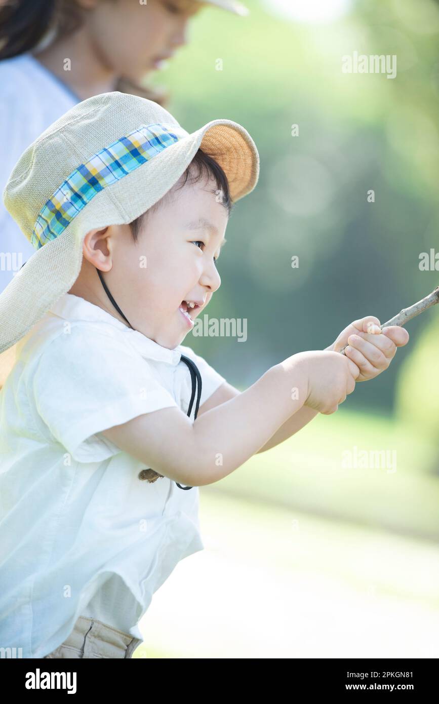 Schwester und Bruder mit Baumzweigen Stockfoto