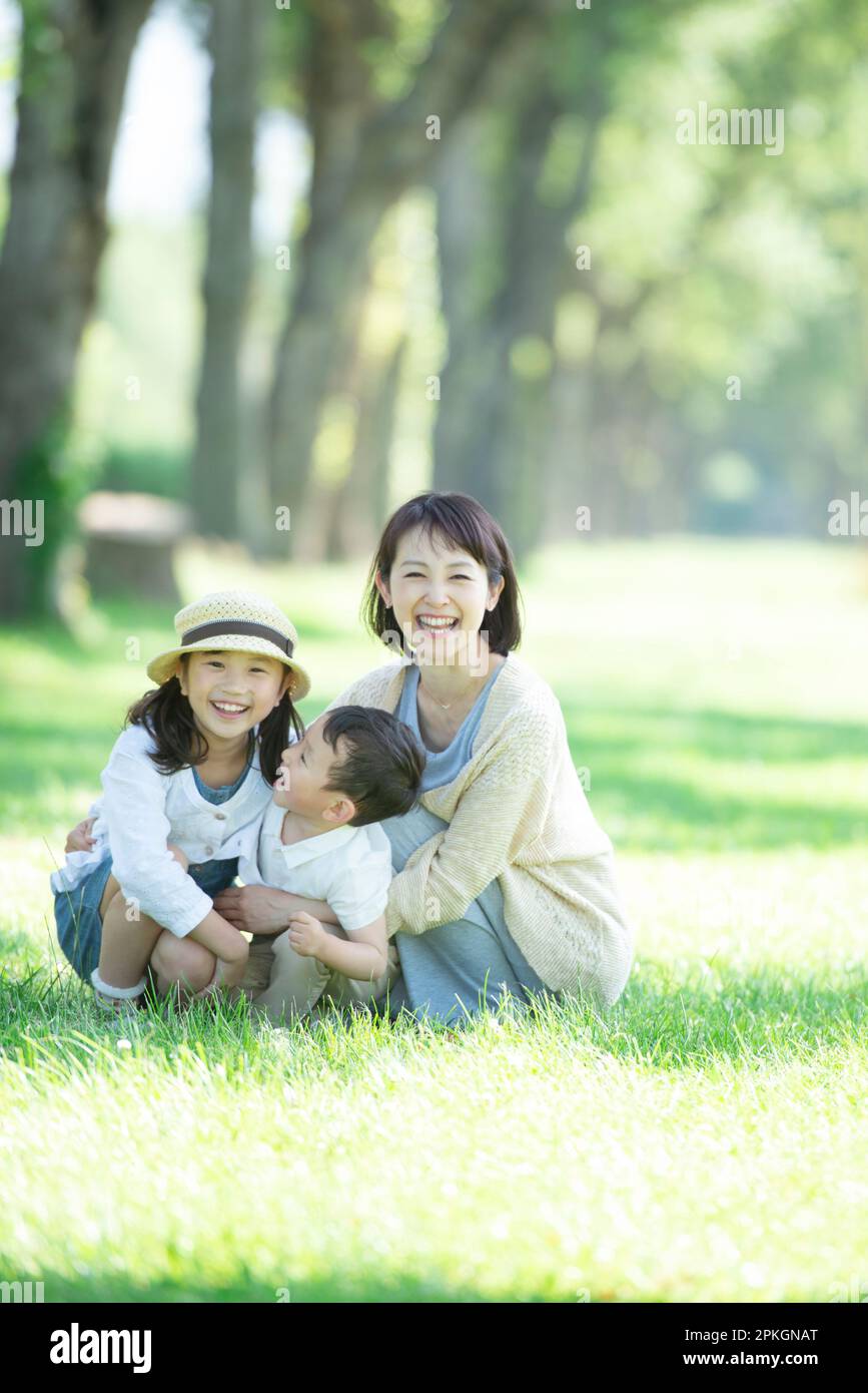 Eltern und Kinder lächeln bei einer Reihe von Pappelbäumen Stockfoto