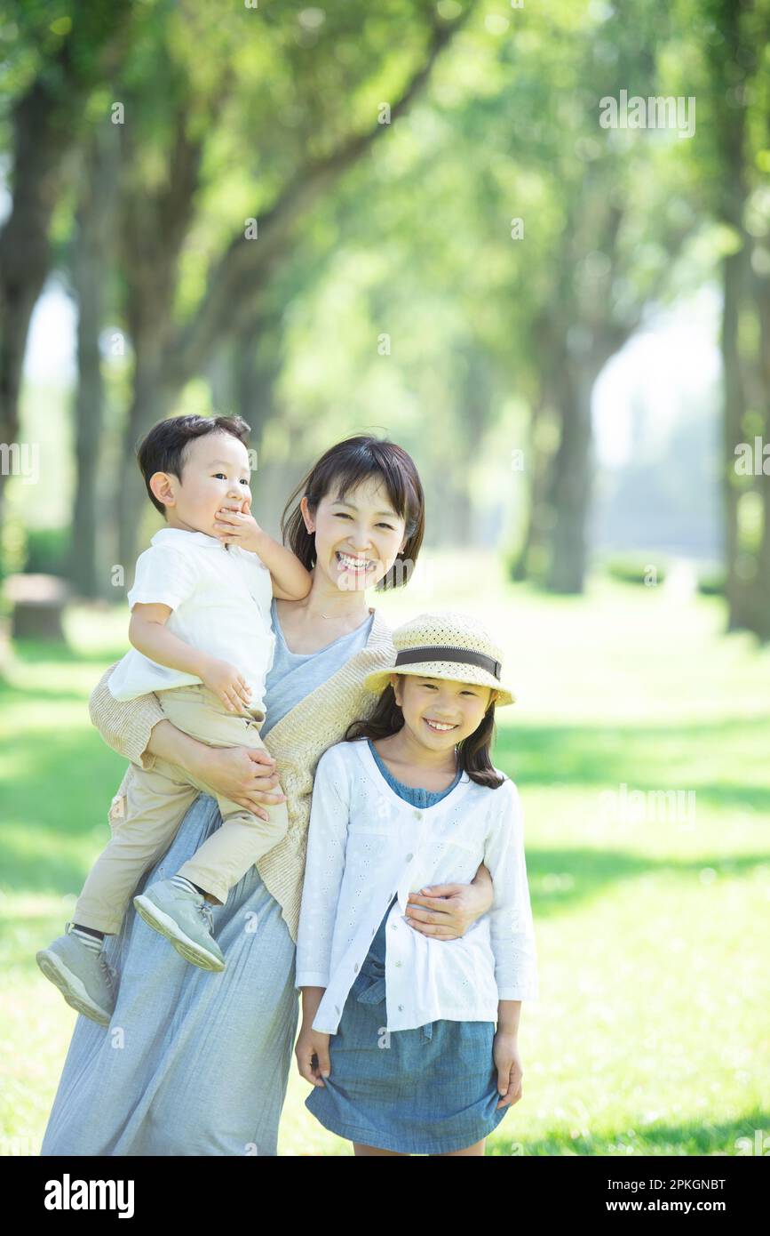 Eltern und Kinder lächeln auf eine Reihe von Pappelbäumen Stockfoto