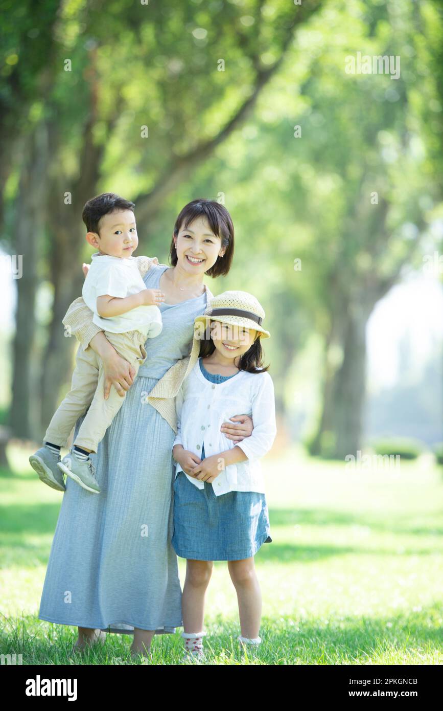 Eltern und Kinder lächeln auf eine Reihe von Pappelbäumen Stockfoto