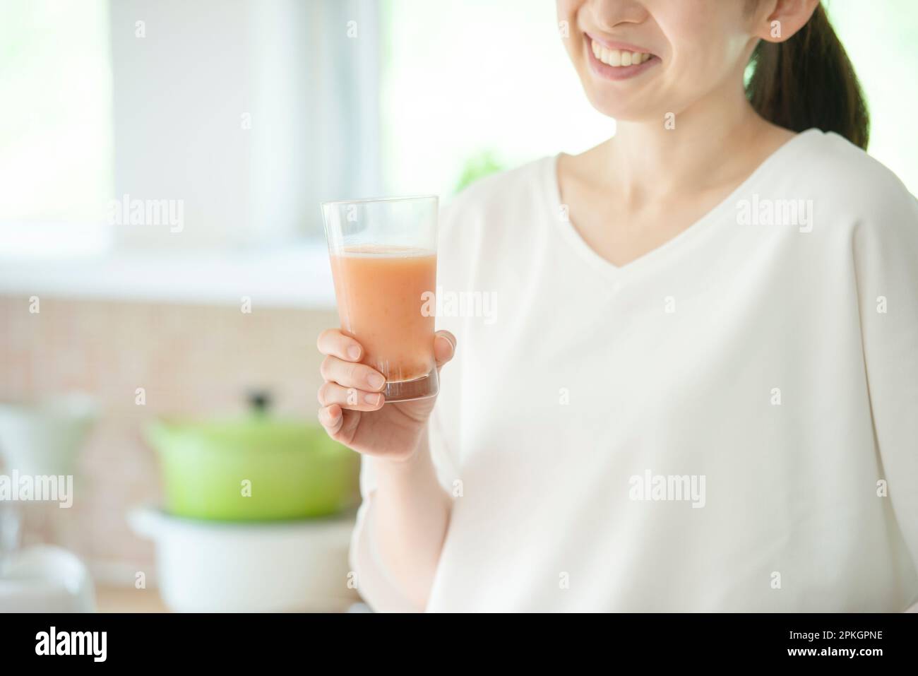 Eine Frau, die Smoothie in der Küche hält Stockfoto