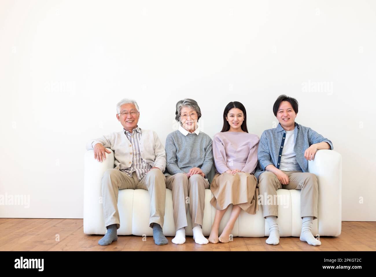 Familie auf einem Sofa sitzt und lächelt Stockfoto