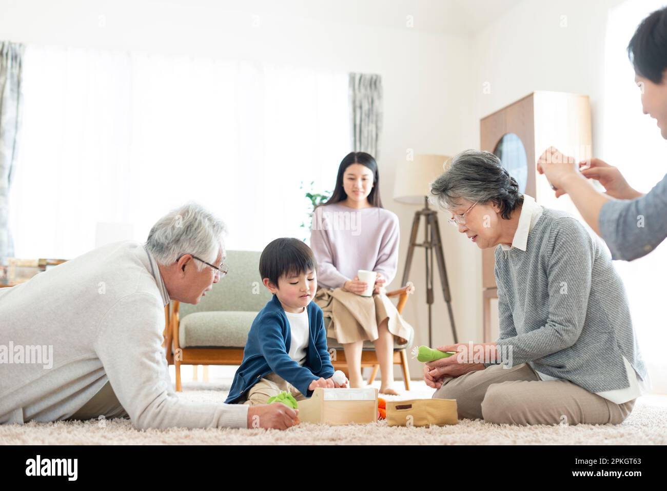 Großeltern und Enkel, die mit Spielzeug spielen Stockfoto