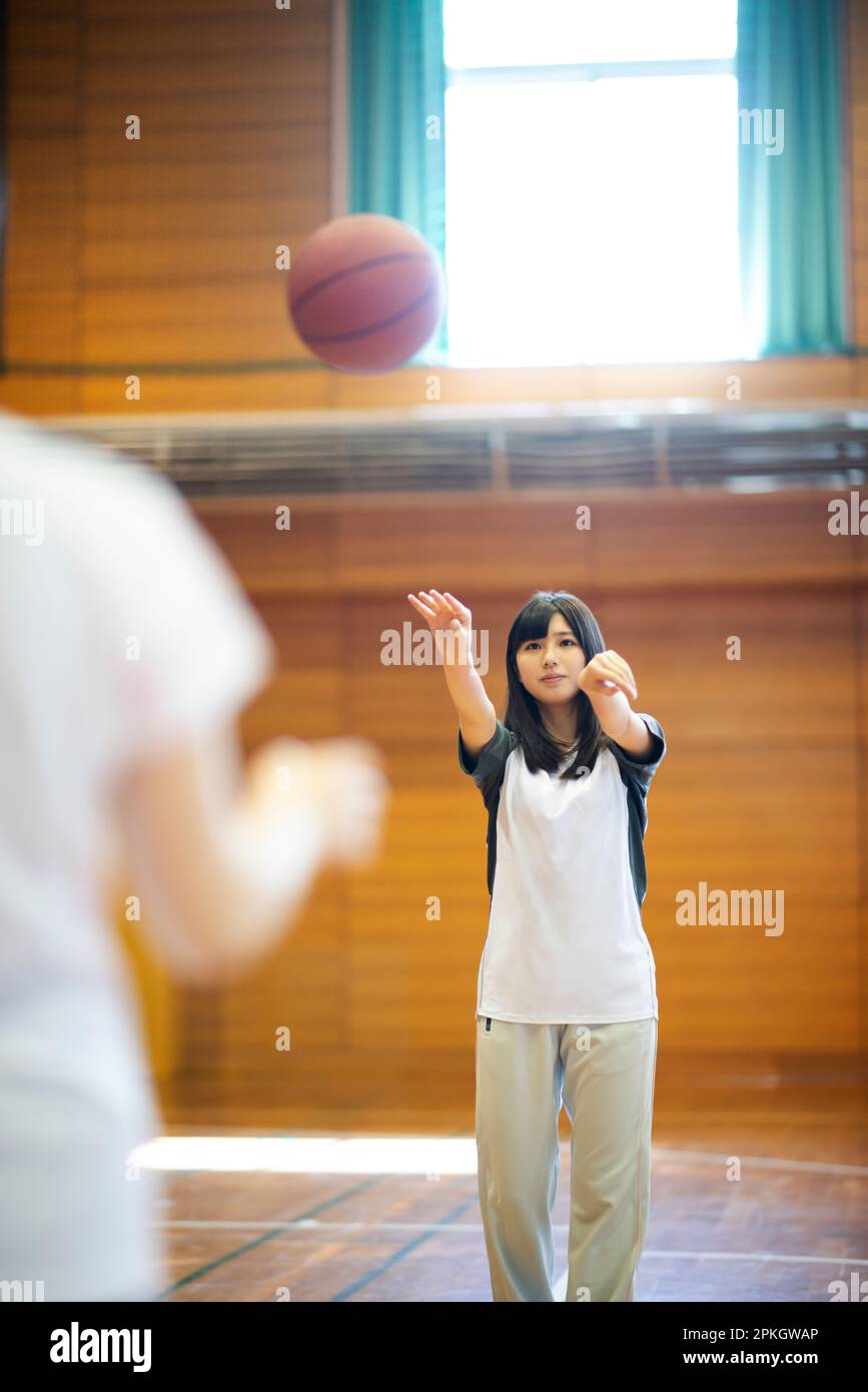 Eine Studentin, die Basketball spielt Stockfoto