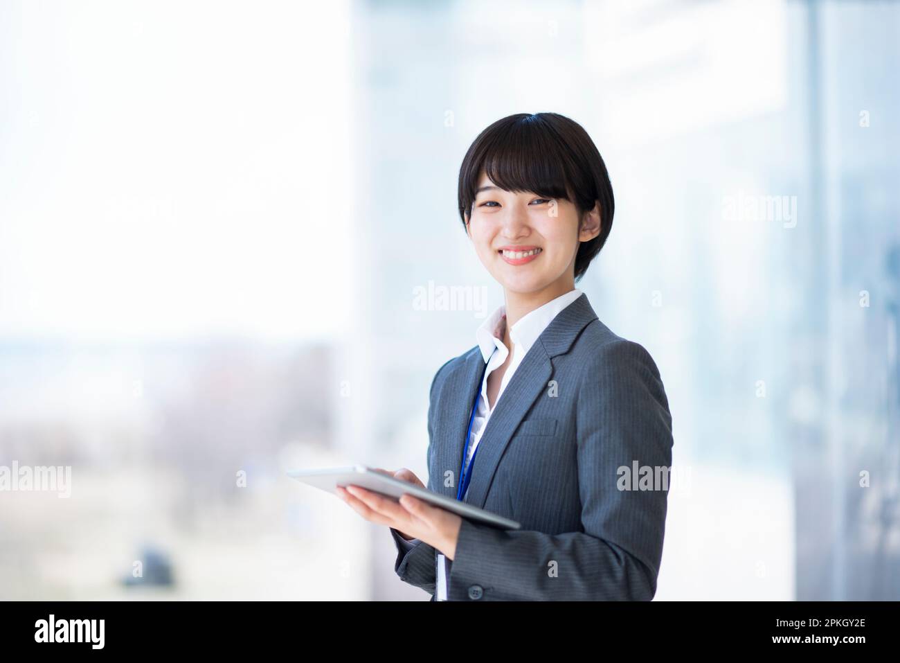 Geschäftsfrau, die einen Tablet-PC hält und lächelt Stockfoto