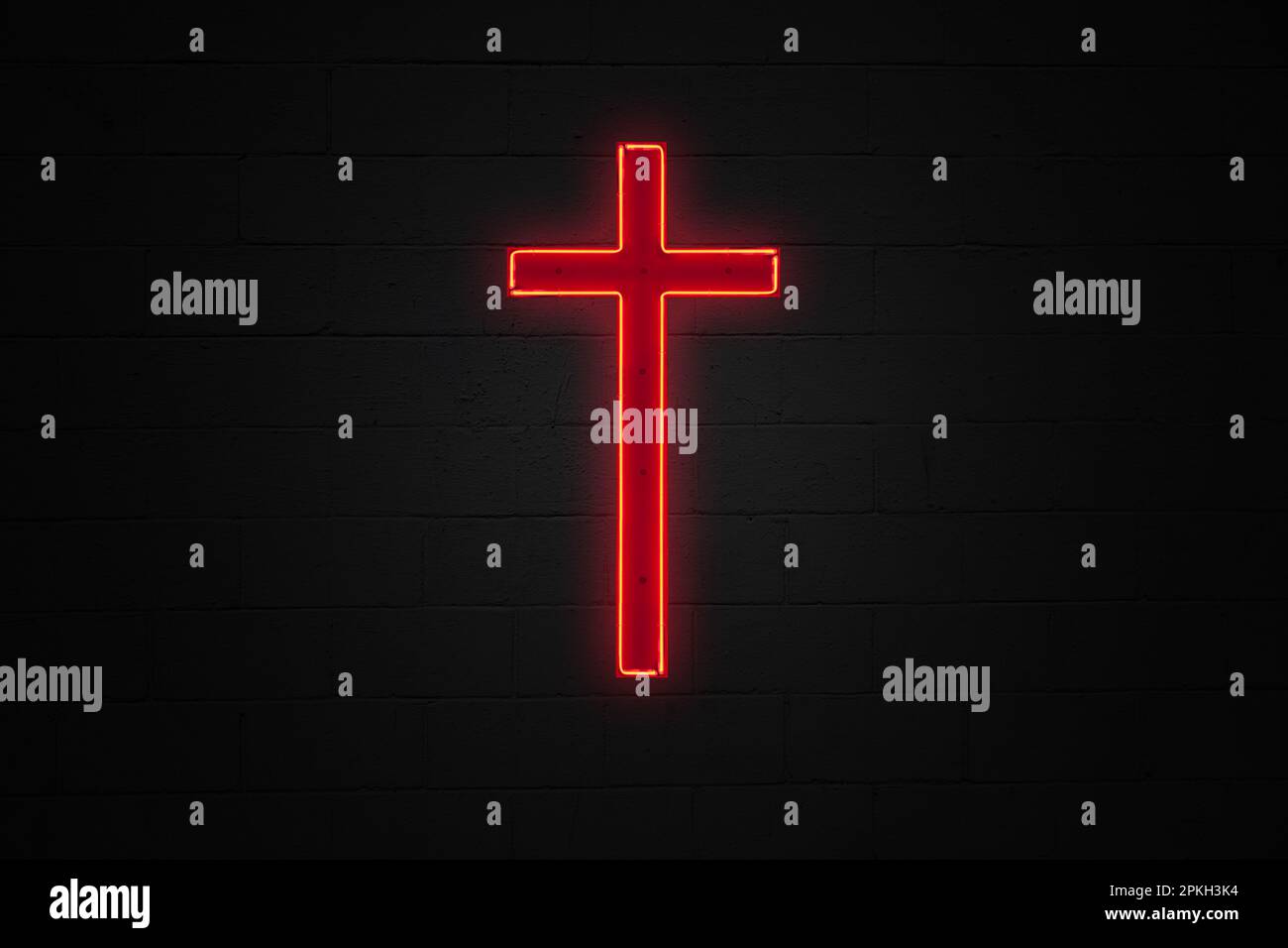 Rotes Neonlicht in Form eines christlichen Kreuzes an einer schwarzen Ziegelwand. Stockfoto