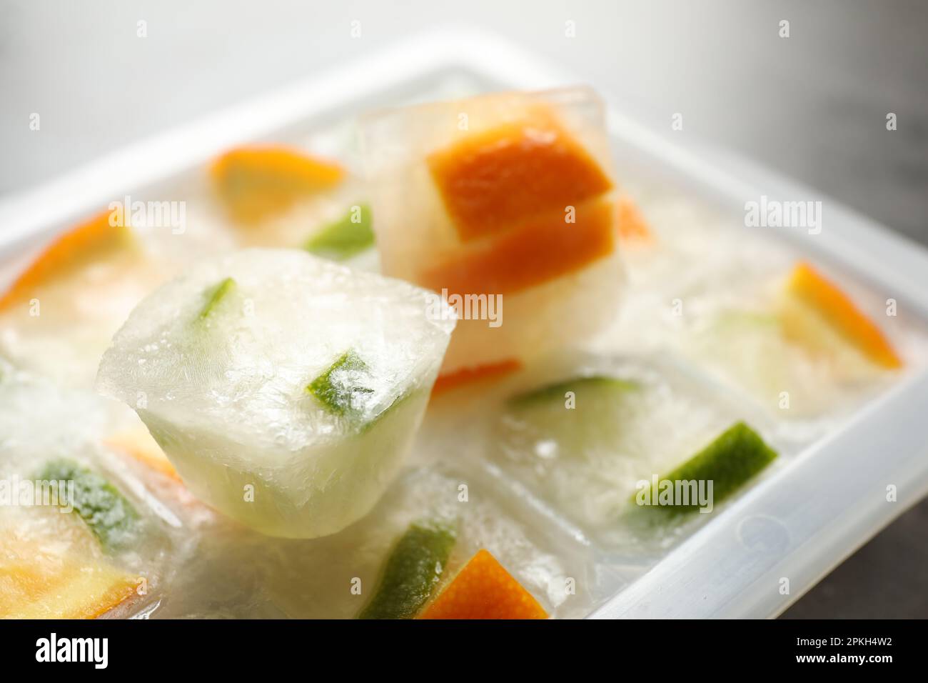 Eiswürfeltablett mit gefrorenem Obst auf dem Tisch, Nahaufnahme Stockfoto