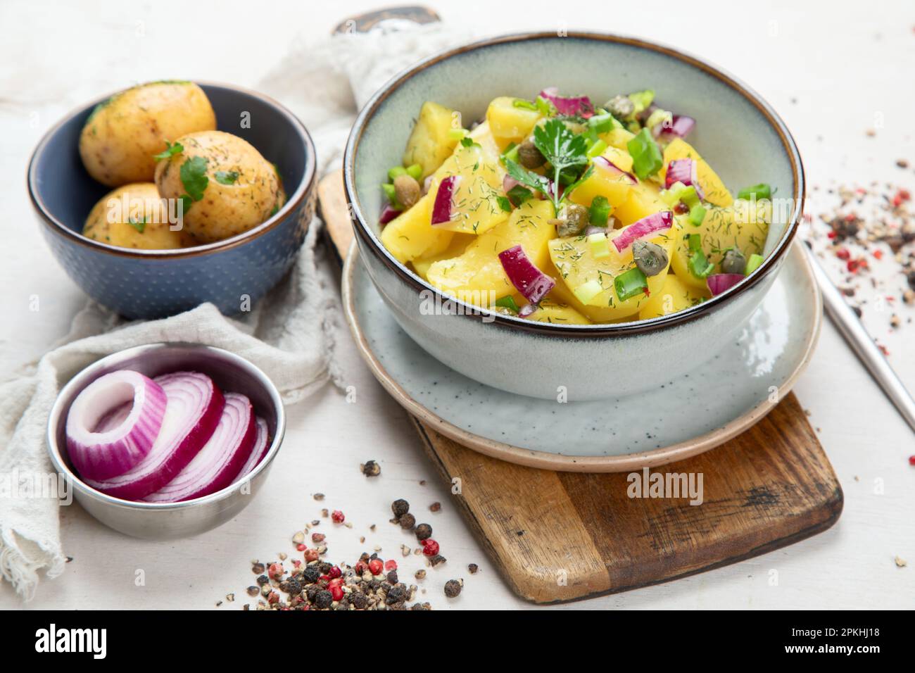 Deutsche Küche. Kartoffelsalat mit roten Zwiebeln und Olivenöl in einer Schüssel auf weißem Hintergrund. Draufsicht. Stockfoto