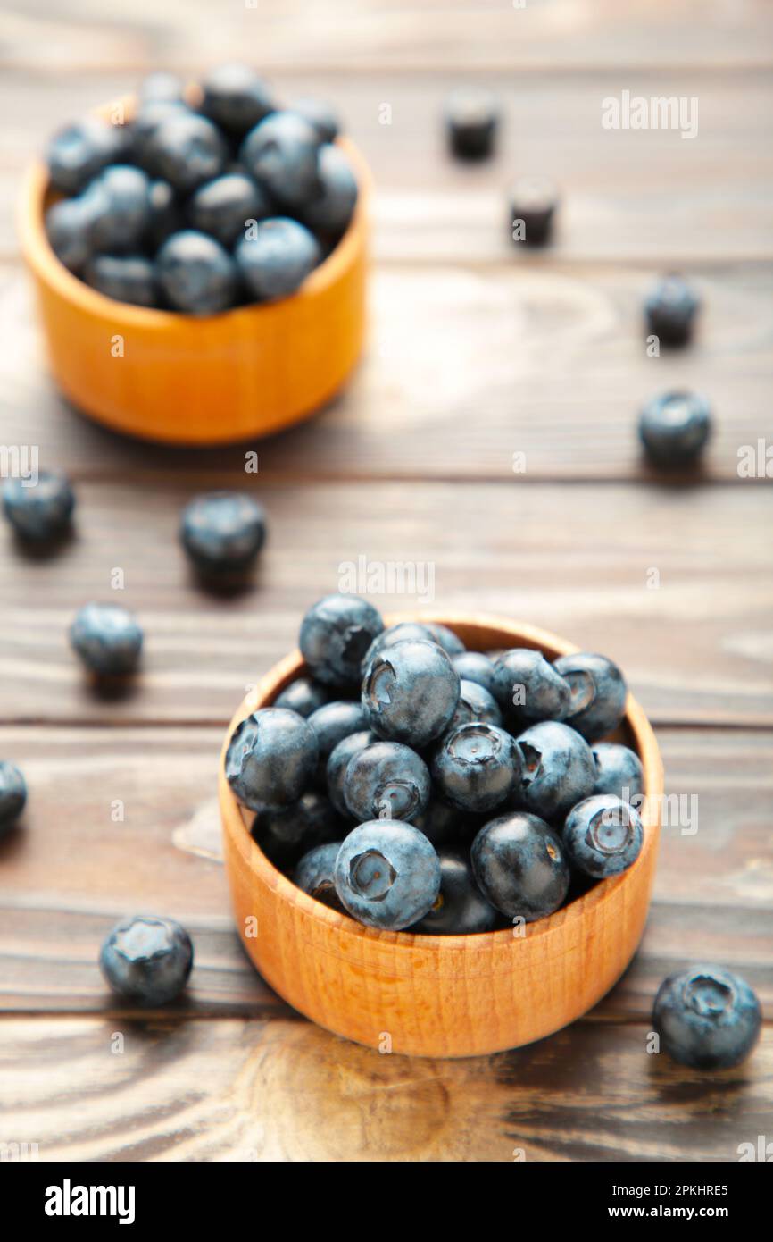 Blaubeeren in Schüsseln auf braunem Holztisch. Draufsicht Stockfoto