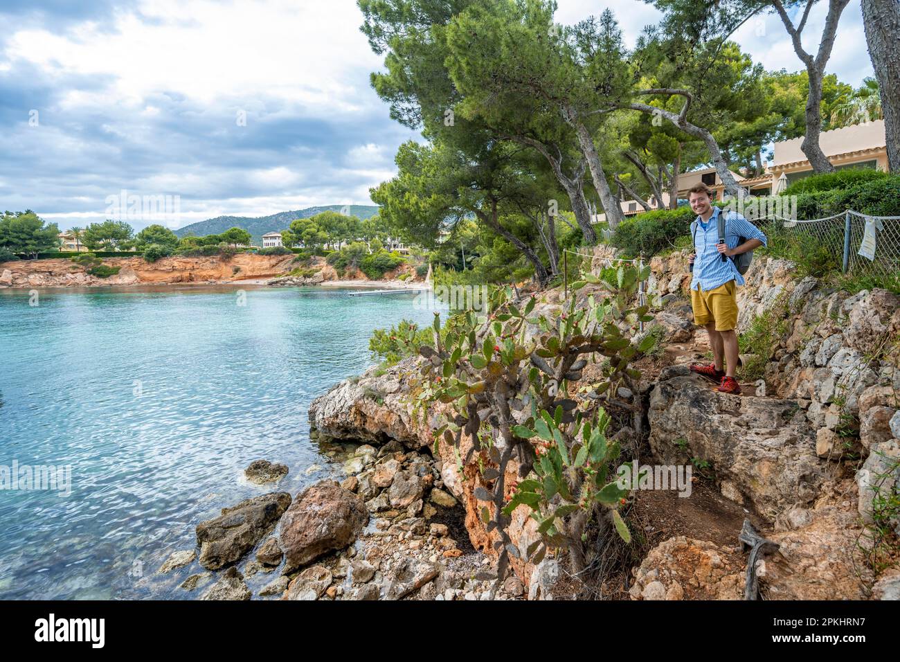 Tourist in einer kleinen felsigen Bucht mit blauem Meer, Cala Punta Negra, Badia de Palma, Mallorca, Balearen, Spanien Stockfoto