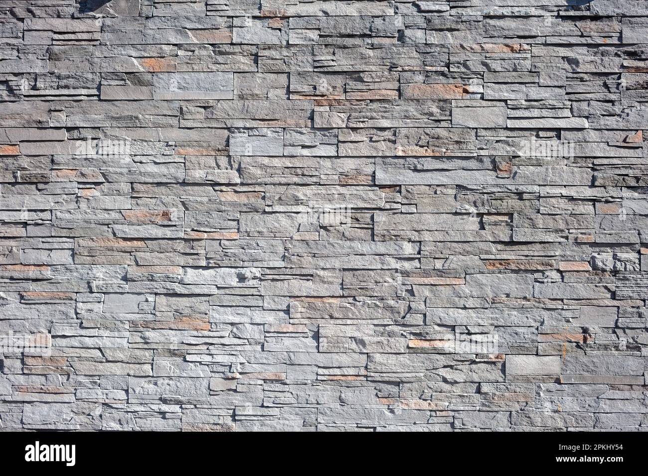 Leere Hintergrundstruktur für Schiefersteinwände. Granitmauerwerk, Mosaikkonstruktion, solide, starke graue Zaunstruktur. Speicherplatz kopieren Stockfoto