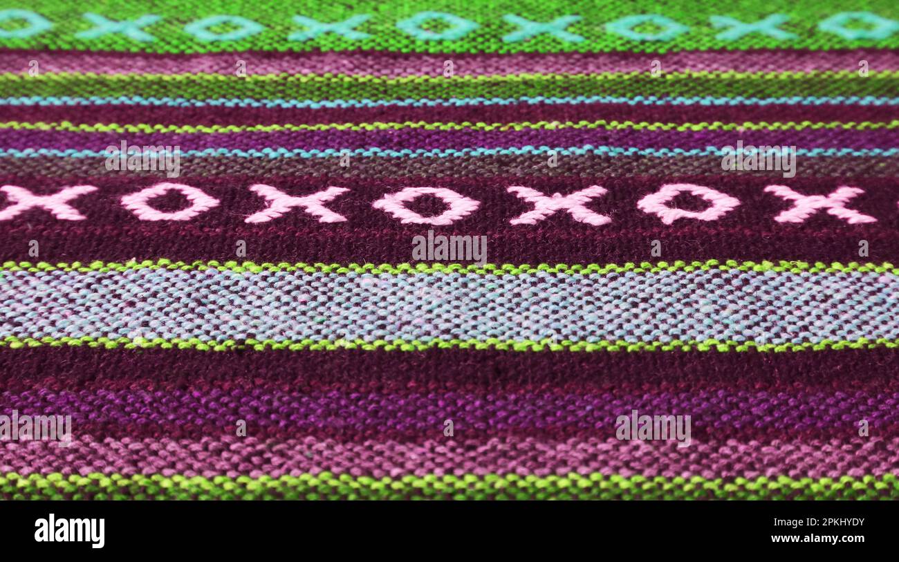 Nahaufnahme des Musters und der Textur des traditionellen Textils der thailändischen Nordregion in tiefem Lila und Olivgrün Stockfoto