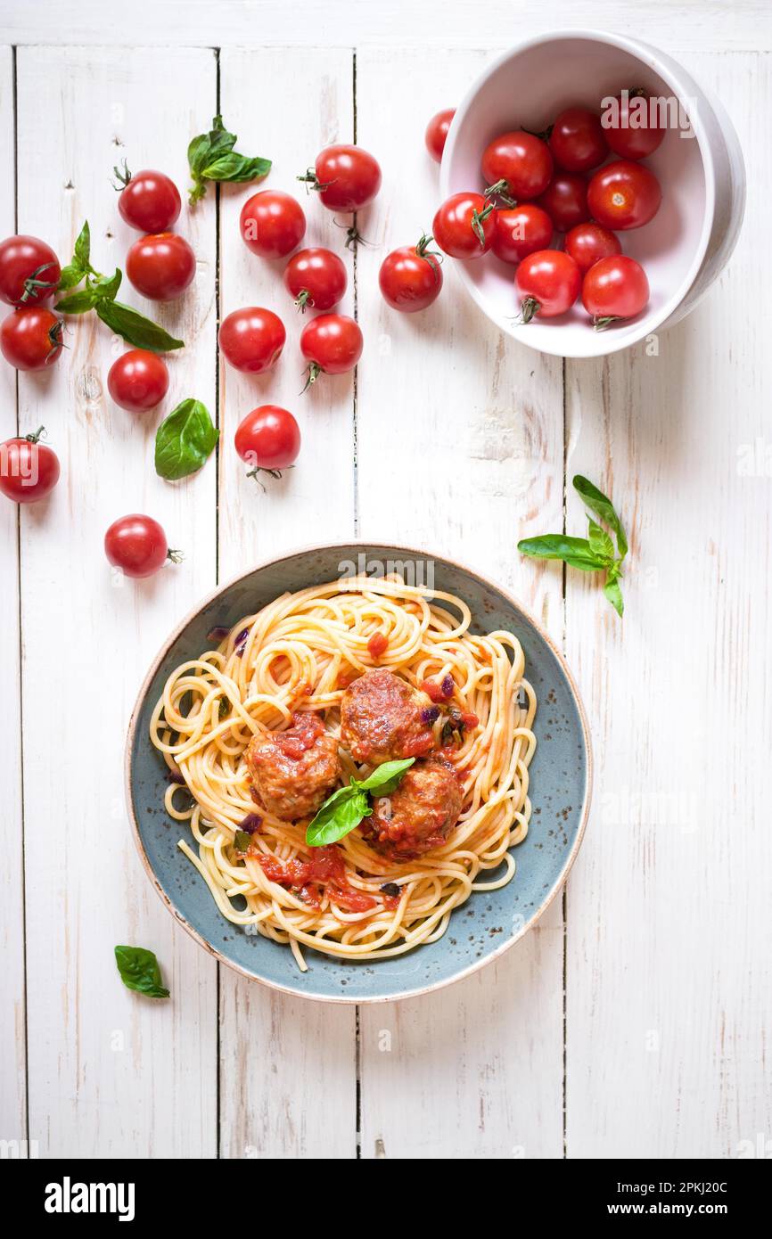 Köstliche Spaghetti mit hackbällchen und Tomatensauce auf einem Teller. Serviert auf einem weißen rustikalen Holztisch. Ein italienisch-amerikanische Gericht. Ansicht von oben Stockfoto