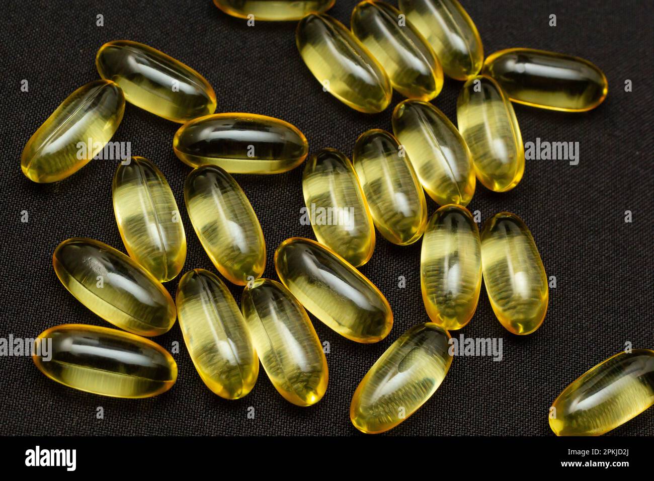 Makro-Nahaufnahme der Omega 3-Gelkapsel auf reflektierendem schwarzem Hintergrund. Stockfoto