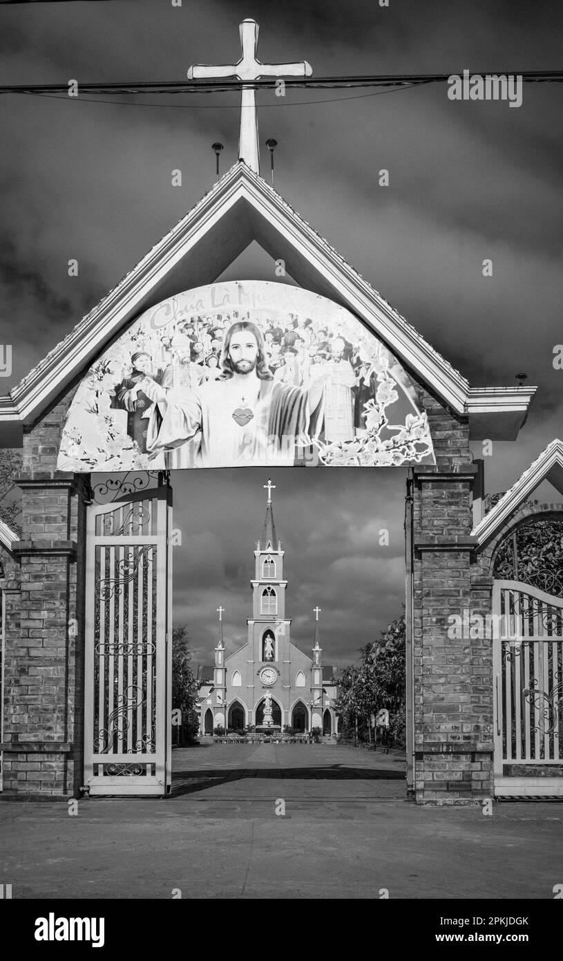 Das Eingangstor zur katholischen Kirche Hoang Yen in Chu Prong, Provinz Gia Lai, Vietnam. Der Slogan über dem Tor lautet: „Jesus ist Frühling (Saison)“ Stockfoto