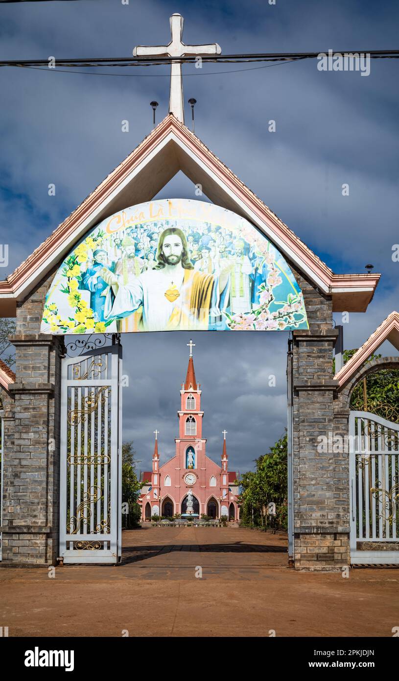 Das Eingangstor zur katholischen Kirche Hoang Yen in Chu Prong, Provinz Gia Lai, Vietnam. Der Slogan über dem Tor lautet: „Jesus ist Frühling (Saison)“ Stockfoto