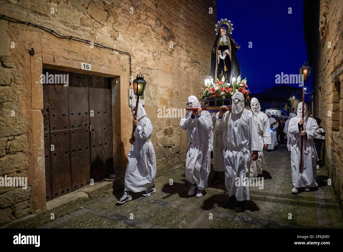 Die Brüder der „Santa de la Vera Cruz“, die die Karfreitagsprozession beginnen, erkunden die Straßen von Torres del Río, Navarra, Spanien. Die Bruderschaft der 'Santa de la Vera Cruz' feiert eine charakteristische Prozession in der Heiligen Woche in Torres del Río, Navarra, Spanien, in der die Bußgesellen weiß gekleidet sind und einen kleinen Teil des Camino de Santiago, In dem sie ein Kreuz tragen, in dem eine Buße die Stille der Nacht bricht, indem sie zum Klang der Schritte schlagen, während andere Mitglieder der Bruderschaft die Virgen de la Dolorosa tragen. (Foto: Elsa A Bravo/SOPA Image Stockfoto Die Brüder der „Santa de la Vera Cruz“, die die Karfreitagsprozession beginnen, erkunden die Straßen von Torres del Río, Navarra, Spanien. Die Bruderschaft der 'Santa de la Vera Cruz' feiert eine charakteristische Prozession in der Heiligen Woche in Torres del Río, Navarra, Spanien, in der die Bußgesellen weiß gekleidet sind und einen kleinen Teil des Camino de Santiago, In dem sie ein Kreuz tragen, in dem eine Buße die Stille der Nacht bricht, indem sie zum Klang der Schritte schlagen, während andere Mitglieder der Bruderschaft die Virgen de la Dolorosa tragen. (Foto: Elsa A Bravo/SOPA Image Stockfoto