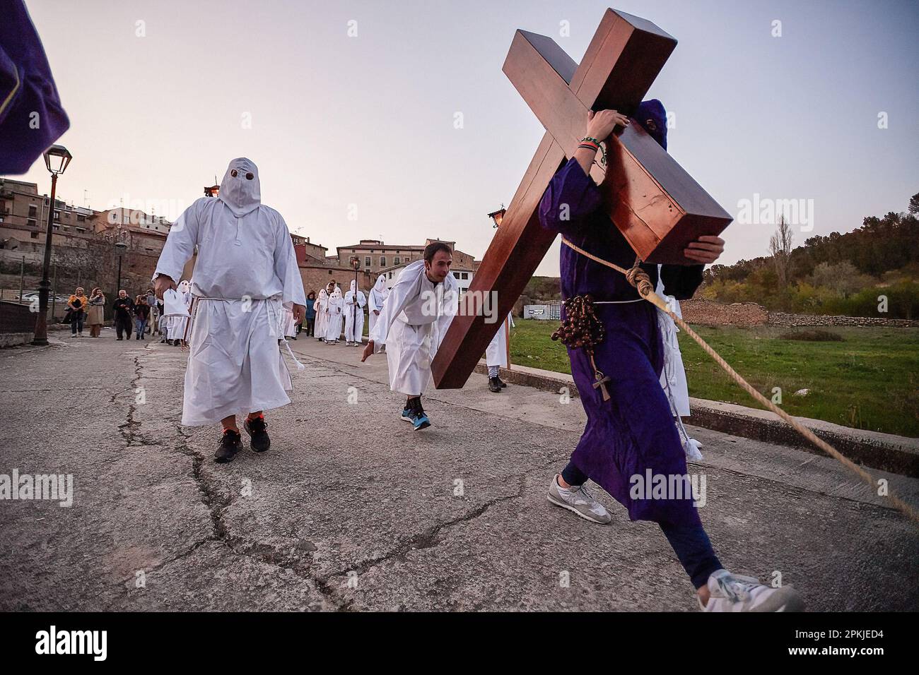 Eine Reue der Bruderschaft der „Santa de la Vera Cruz“, transportiert das Kreuz Jesu Christi, begleitet von einer anderen Reue, die die Stille der Prozession bricht, indem sie es während der Feier des Karfreitags in der Stadt Torres del Río, Navarra, Spanien, trifft. Die Bruderschaft der 'Santa de la Vera Cruz' feiert eine charakteristische Prozession in der Heiligen Woche in Torres del Río, Navarra, Spanien, in der die Bußgesellen weiß gekleidet sind und einen kleinen Teil des Camino de Santiago, In dem sie ein Kreuz tragen, in dem ein Buße die Stille der Nacht bricht, indem er zum Klang schlägt Stockfoto Eine Reue der Bruderschaft der „Santa de la Vera Cruz“, transportiert das Kreuz Jesu Christi, begleitet von einer anderen Reue, die die Stille der Prozession bricht, indem sie es während der Feier des Karfreitags in der Stadt Torres del Río, Navarra, Spanien, trifft. Die Bruderschaft der 'Santa de la Vera Cruz' feiert eine charakteristische Prozession in der Heiligen Woche in Torres del Río, Navarra, Spanien, in der die Bußgesellen weiß gekleidet sind und einen kleinen Teil des Camino de Santiago, In dem sie ein Kreuz tragen, in dem ein Buße die Stille der Nacht bricht, indem er zum Klang schlägt Stockfoto