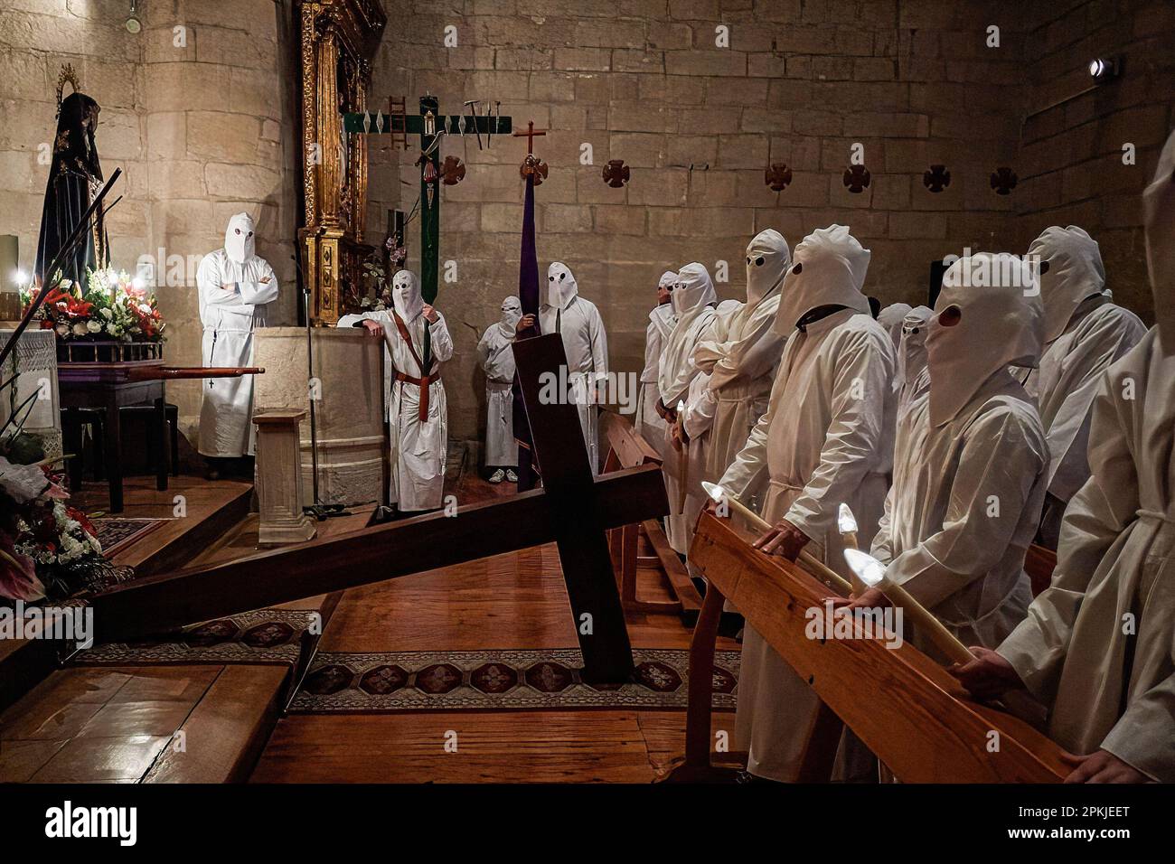 In der Kirche von San Andrés warten die Bußgänger der Brüderschaft „Santa de la Vera Cruz“ darauf, in Prozession durch die Straßen von Torres del Rio, Navarra, Spanien, zu gehen. Die Bruderschaft der 'Santa de la Vera Cruz' feiert eine charakteristische Prozession in der Heiligen Woche in Torres del Río, Navarra, Spanien, in der die Bußgesellen weiß gekleidet sind und einen kleinen Teil des Camino de Santiago, In dem sie ein Kreuz tragen, in dem eine Buße die Stille der Nacht bricht, indem sie zum Klang der Schritte schlagen, während andere Mitglieder der Bruderschaft die Virgen de la Dolorosa tragen. (Foto von Stockfoto In der Kirche von San Andrés warten die Bußgänger der Brüderschaft „Santa de la Vera Cruz“ darauf, in Prozession durch die Straßen von Torres del Rio, Navarra, Spanien, zu gehen. Die Bruderschaft der 'Santa de la Vera Cruz' feiert eine charakteristische Prozession in der Heiligen Woche in Torres del Río, Navarra, Spanien, in der die Bußgesellen weiß gekleidet sind und einen kleinen Teil des Camino de Santiago, In dem sie ein Kreuz tragen, in dem eine Buße die Stille der Nacht bricht, indem sie zum Klang der Schritte schlagen, während andere Mitglieder der Bruderschaft die Virgen de la Dolorosa tragen. (Foto von Stockfoto