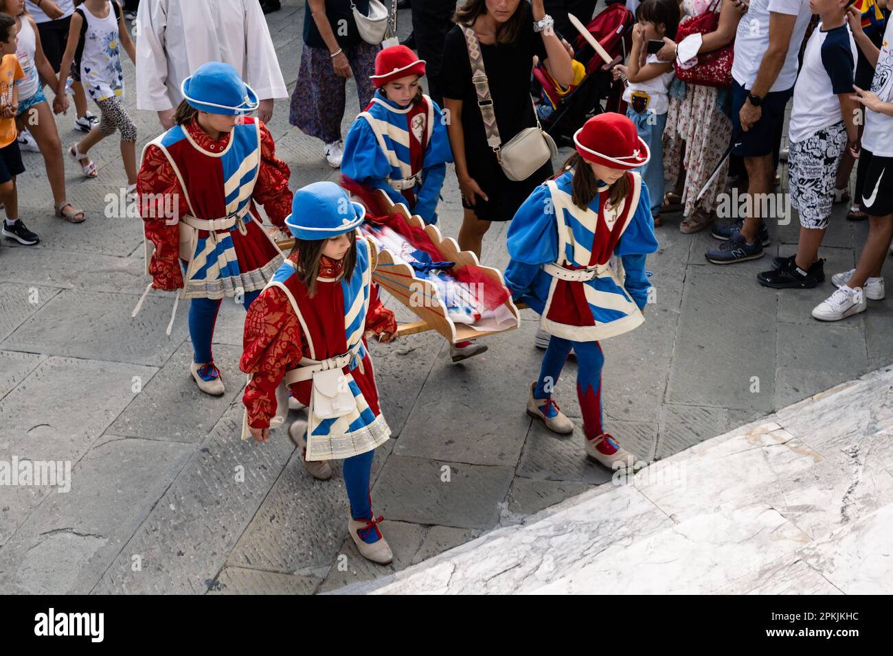 Siena, Italien - August 14 2022: Mädchen der Pantera oder Panther Contrada tragen Cero Votivo Kerzen bei der Prozession vor dem Palio. Stockfoto