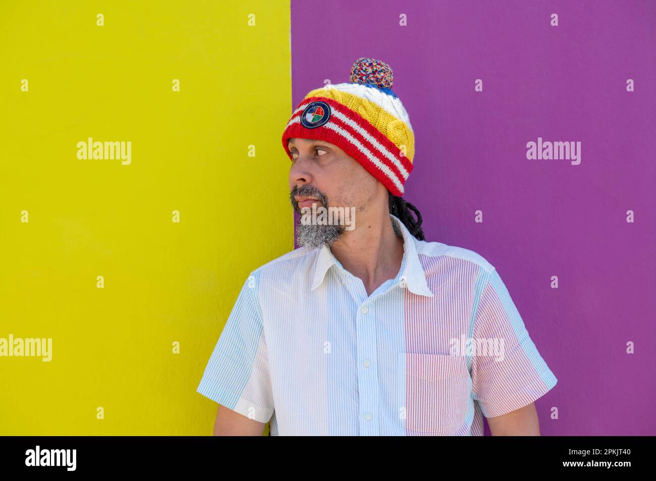 Nahaufnahme eines Mannes, der an einer bunten Wand steht Stockfoto