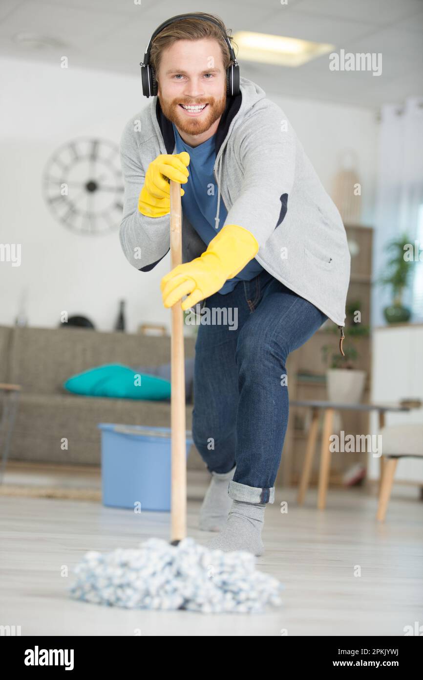 Ein Mann, der zu Hause den Boden gewischt Stockfoto