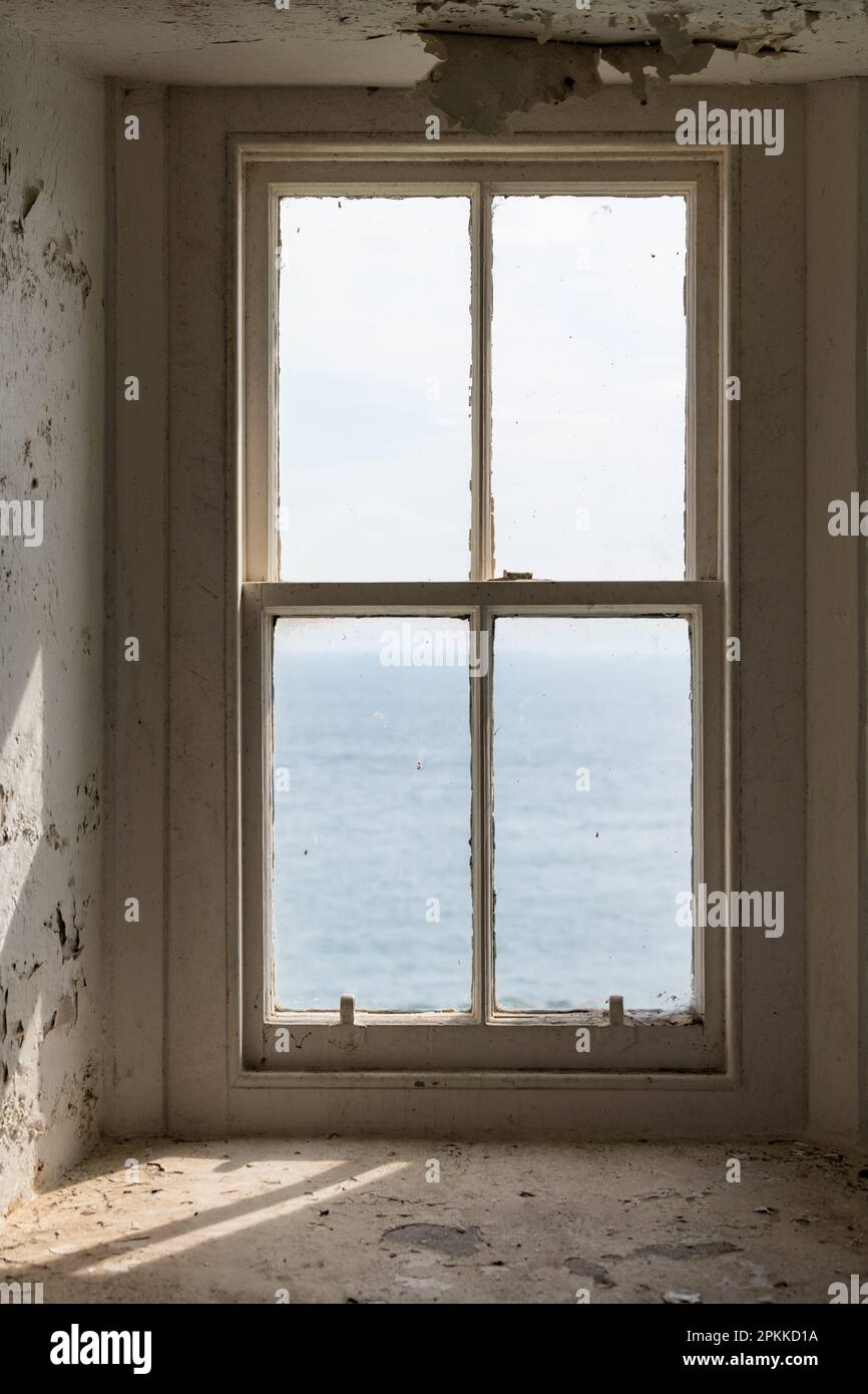 Altes Schiebefenster mit Blick auf das Meer in einem verlassenen Grundstück Stockfoto