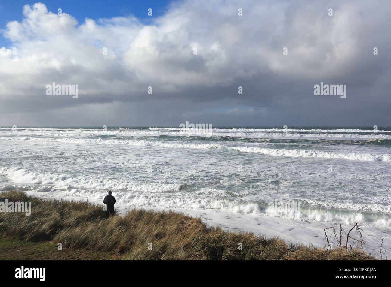 Ein Mann blickt über stürmische Meere und Gezeiten an der pazifikküste im Nordwesten von Oregon. Stockfoto