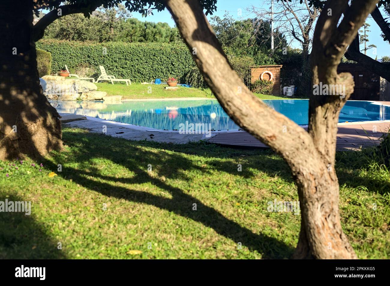 Swimmingpool umgeben von Bäumen in einem Park am Meer bei Sonnenuntergang Stockfoto