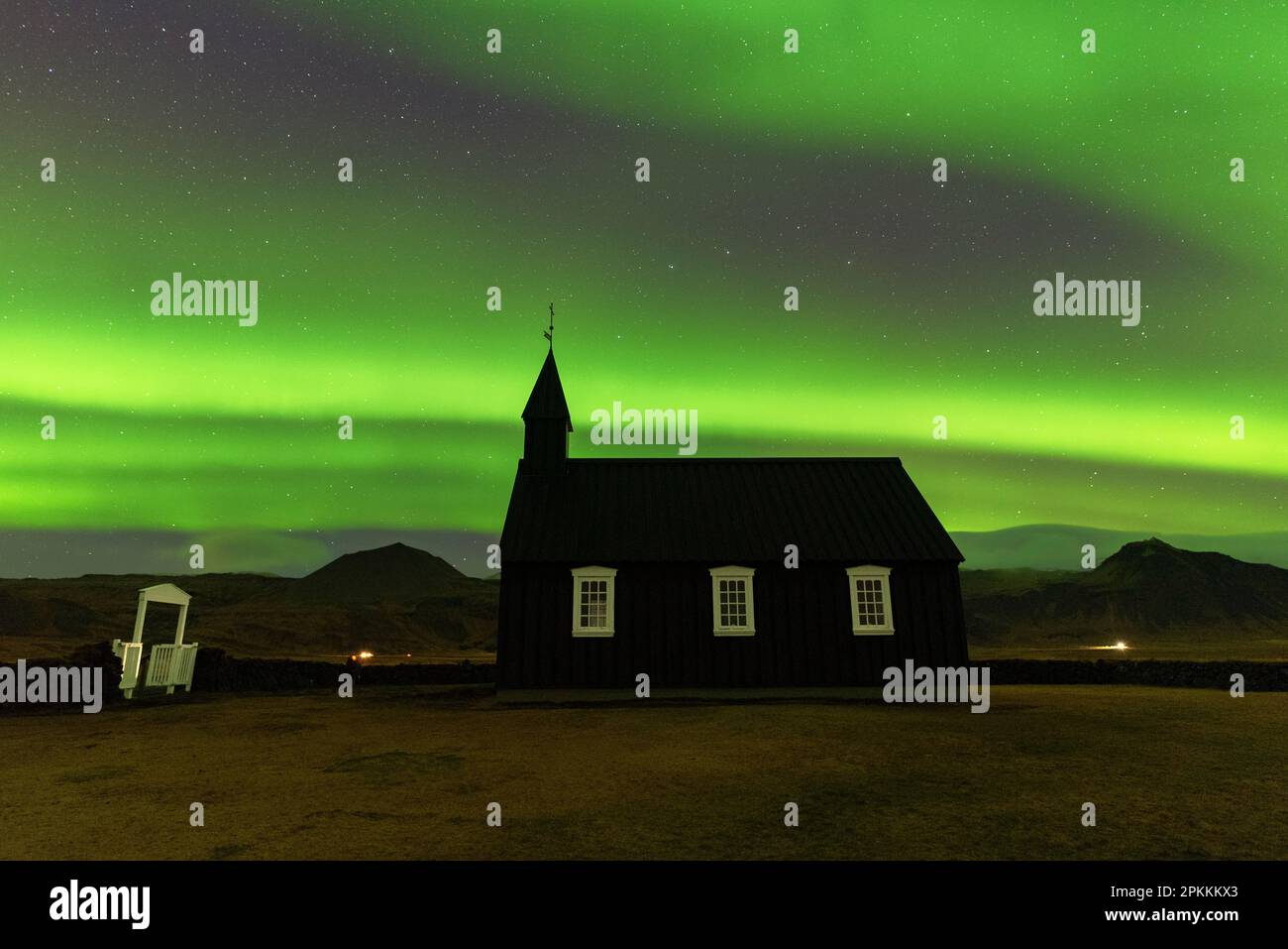 Schwarze hölzerne Budakirkja-Kirche unter den grünen Nordlichtern (Aurora Borealis) und die Sternennacht, Budir, Halbinsel Snaefellsness Stockfoto