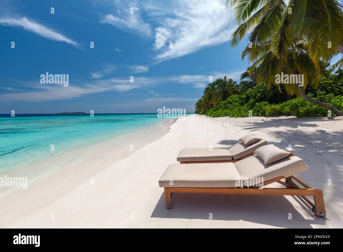 Holzliegen an einem wunderschönen tropischen Strand, den Malediven, dem Indischen Ozean, Asien Stockfoto