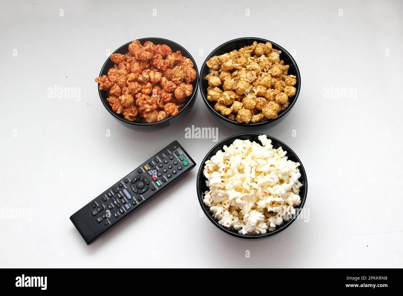 Aromatisiertes Popcorn: Natürlich, mit Chili und Karamell, eine Auswahl an Snacks mit Getränken, die für einen Film bereit sind Stockfoto