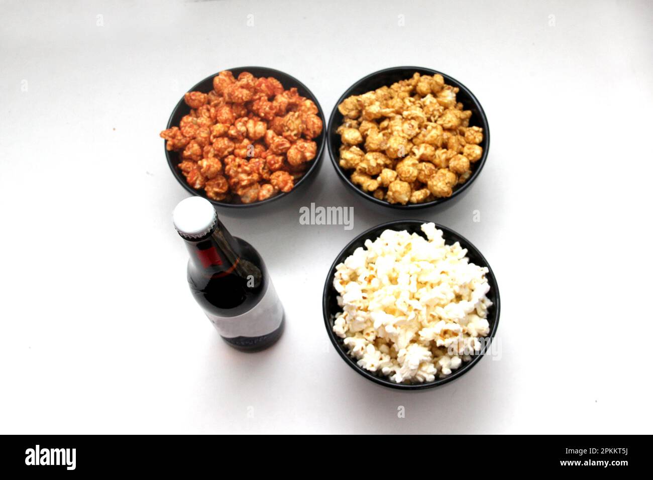 Aromatisiertes Popcorn: Natürlich, mit Chili und Karamell, eine Auswahl an Snacks mit Getränken, die für einen Film bereit sind Stockfoto