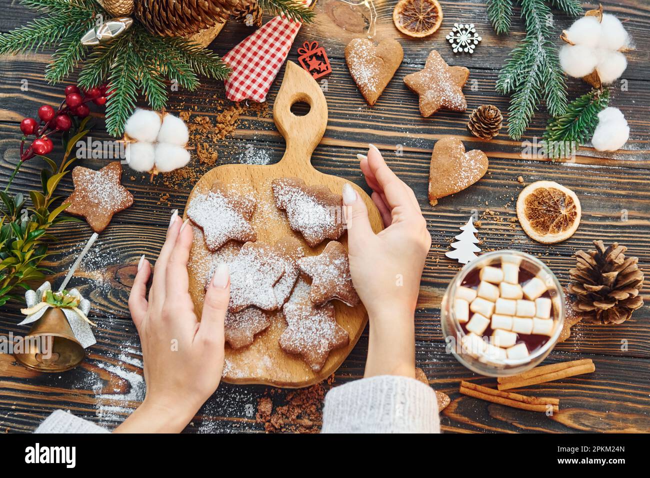 Eine Frau, die den Tisch dekoriert. Hintergrund zu Weihnachten. Stockfoto