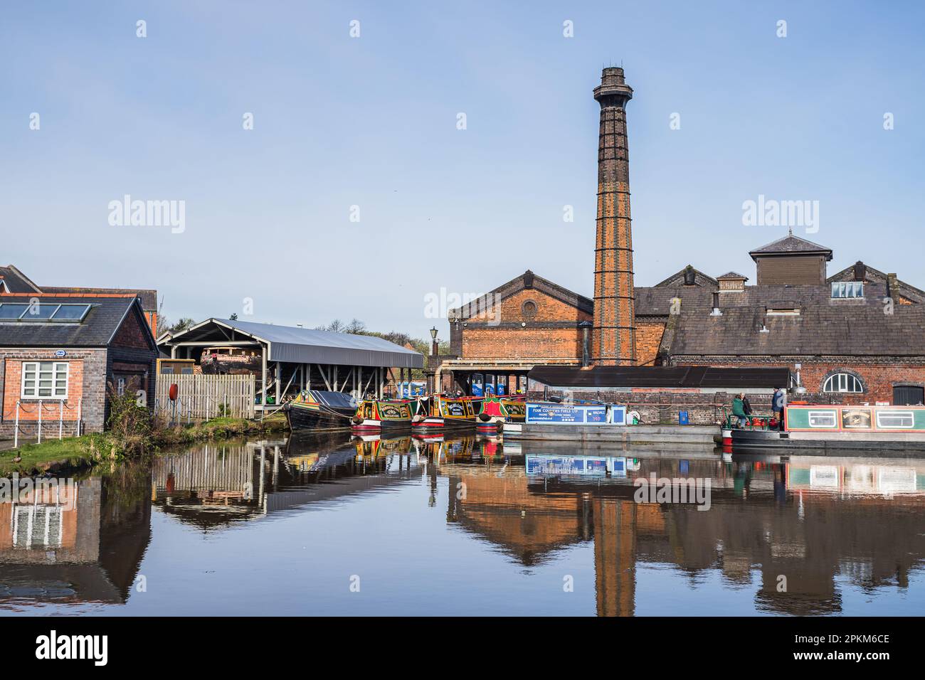 Schmale Boote, die um das Pumpenhaus am Ellesmere Port am Ellesmere Canal festgemacht wurden, spiegeln sich im April 2023 im Wasser wider. Stockfoto