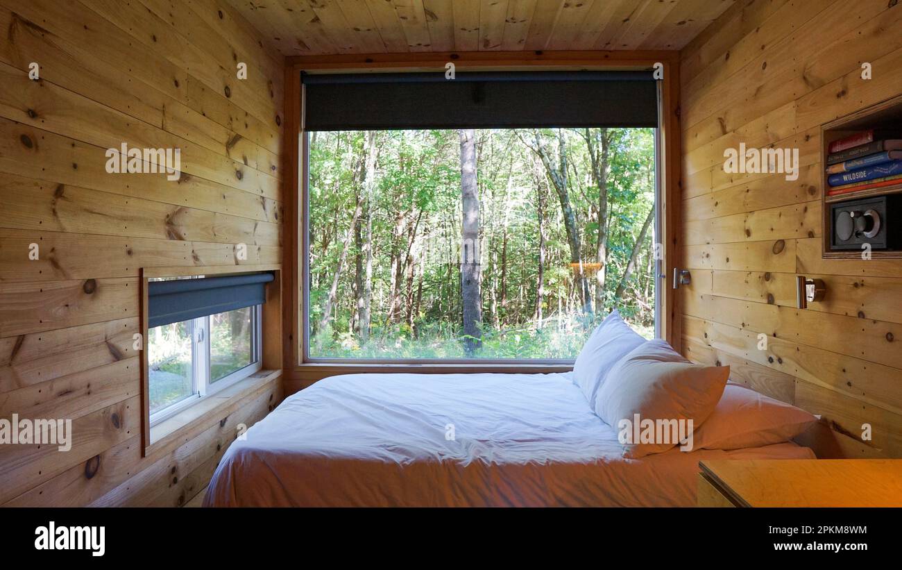 Rückzug in die Natur: Gemütliche Hütte im Wald mit atemberaubender Aussicht durch das große Fenster | winzige Hütte | Glamping | abseits des Rasters Stockfoto