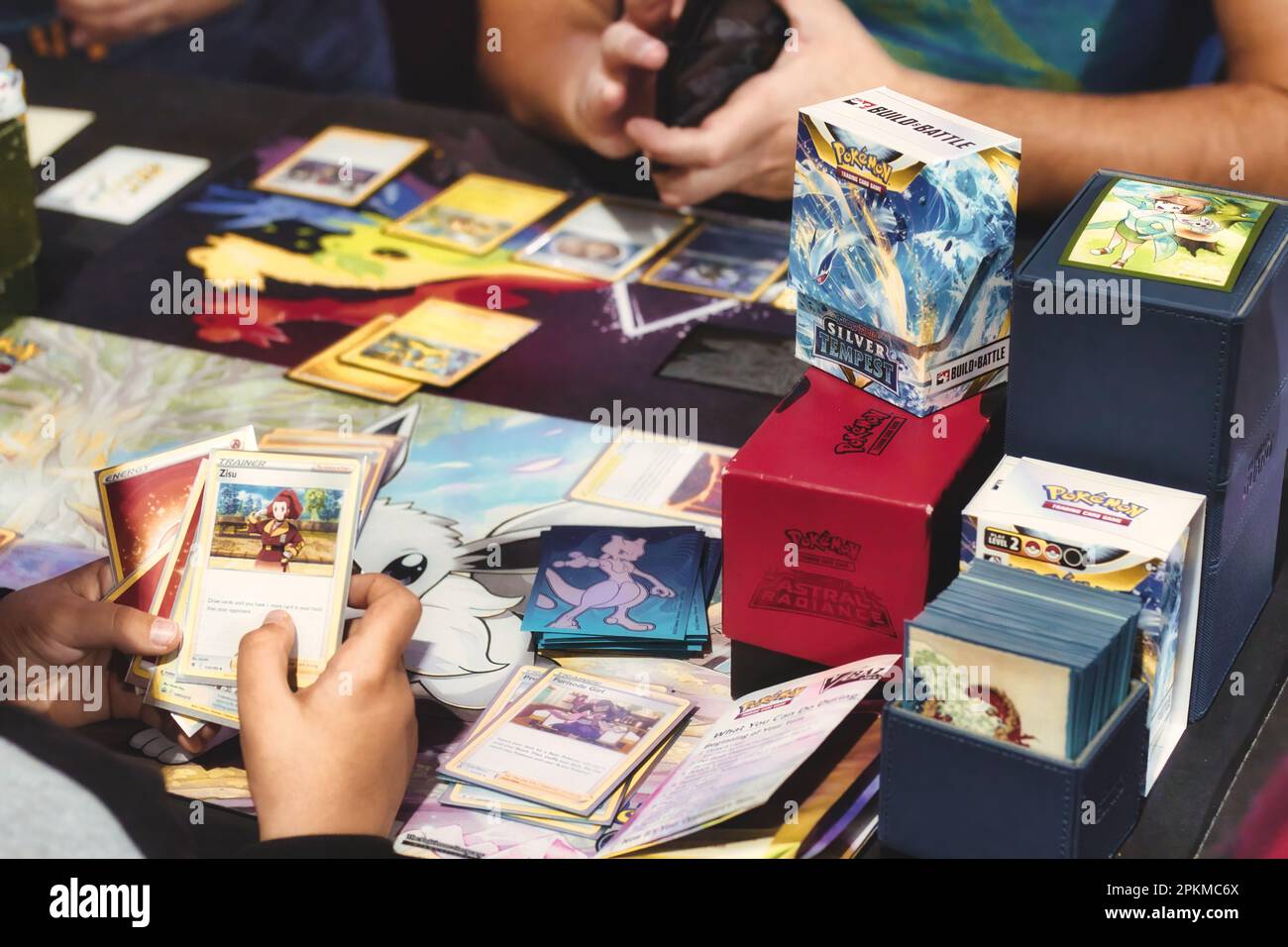 Zwei nicht wiedererkennbare weiße, kaukasische Kinder, die mit Pokemon-Karten auf einem Tisch spielen Stockfoto