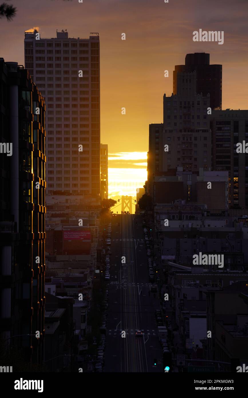 San Francisco, Usa. 08. April 2023. Blick auf den Sonnenaufgang entlang der California Street in San Francisco. Die aufgehende Sonne verläuft zwischen der California Street und der Gough Street in San Francisco. Die Sonne rammt an den Gebäuden vorbei und erhebt sich über die Bay Bridge. Sie findet vom 8. April bis zum 10. April statt und geschieht zweimal im Jahr. Am 8. April versammelten sich Hunderte von Menschen an der Kreuzung von California Street und Gough Street. Viele von ihnen sind mit professioneller Fotoausrüstung ausgestattet und fotografieren den Sonnenaufgang mitten auf der Straße. Kredit: SOPA Images Limited/Alamy Live News Stockfoto